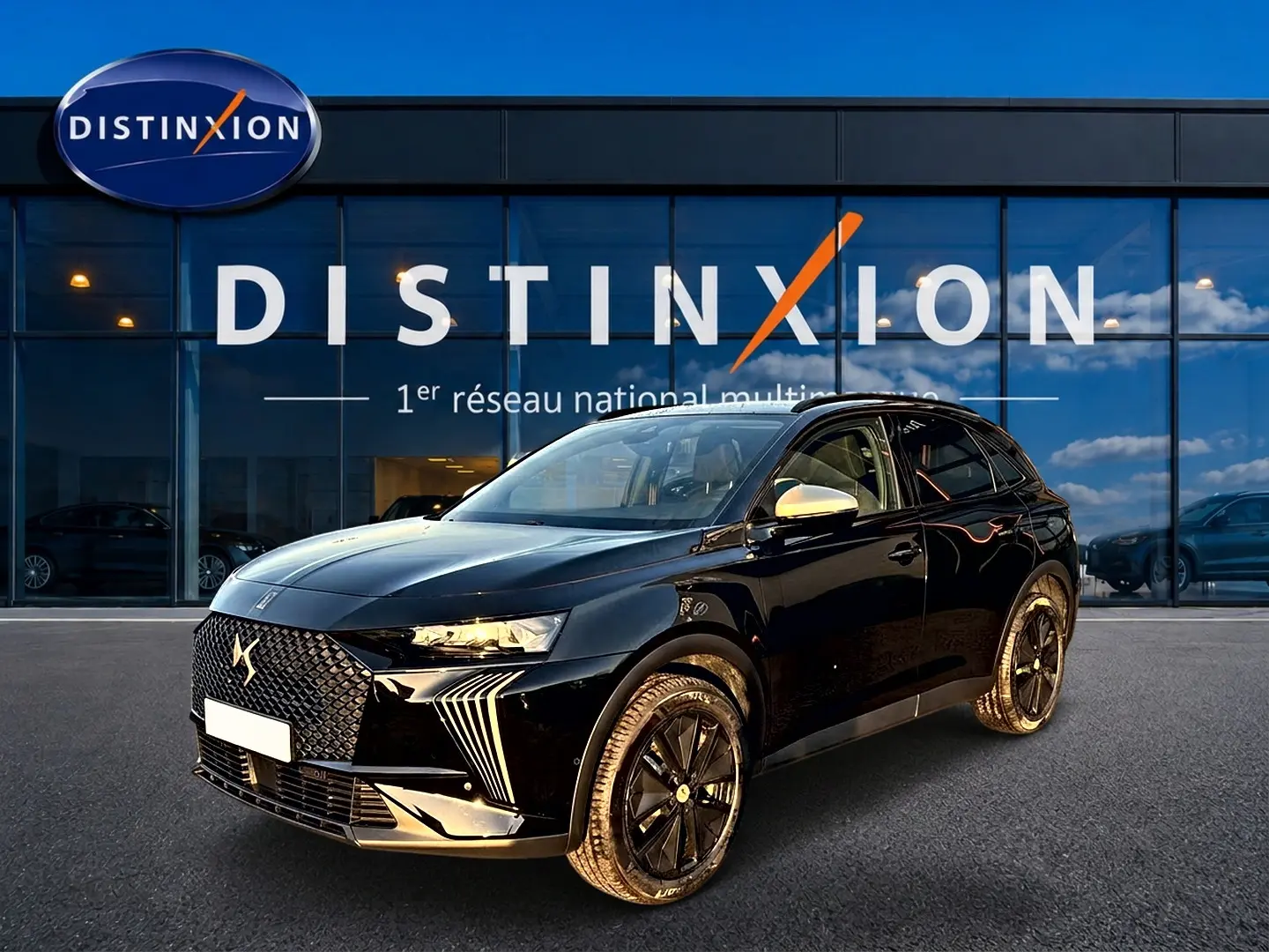 DS7 1.5 BlueHDi noir vue 3/4 avant avec calandre distinctive et jantes noires devant un showroom Distinxion.
