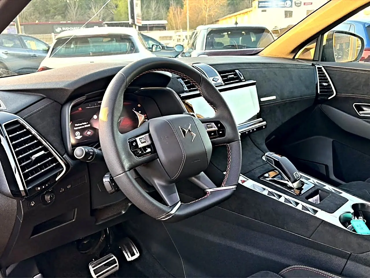 Intérieur noir du DS7 1.5 BlueHDi 130 Performance Line vu côté conducteur, volant cuir et écran tactile central.