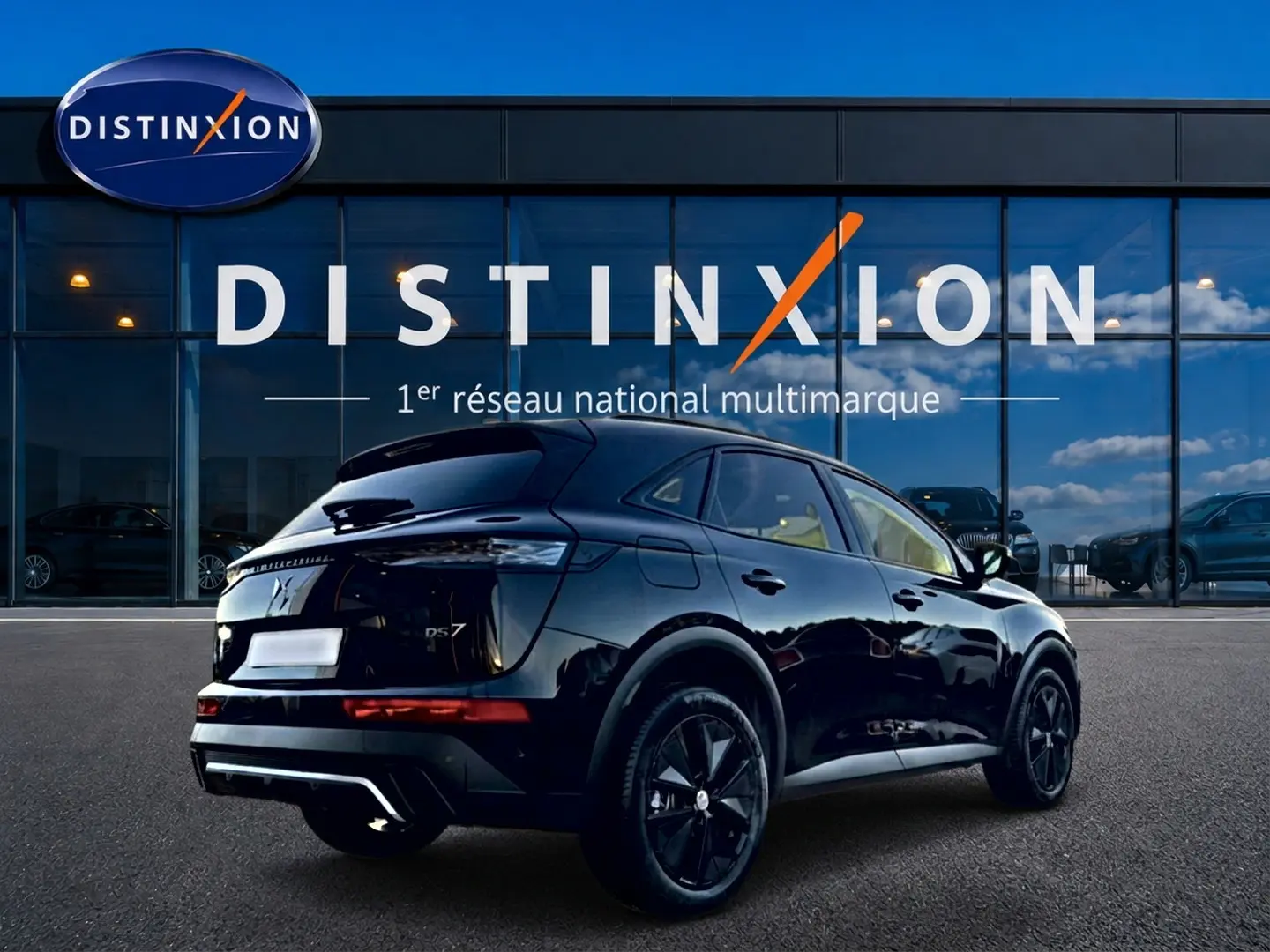 Vue 3/4 arrière droite d'un DS7 noir brillant avec jantes noires devant une vitrine Distinxion.
