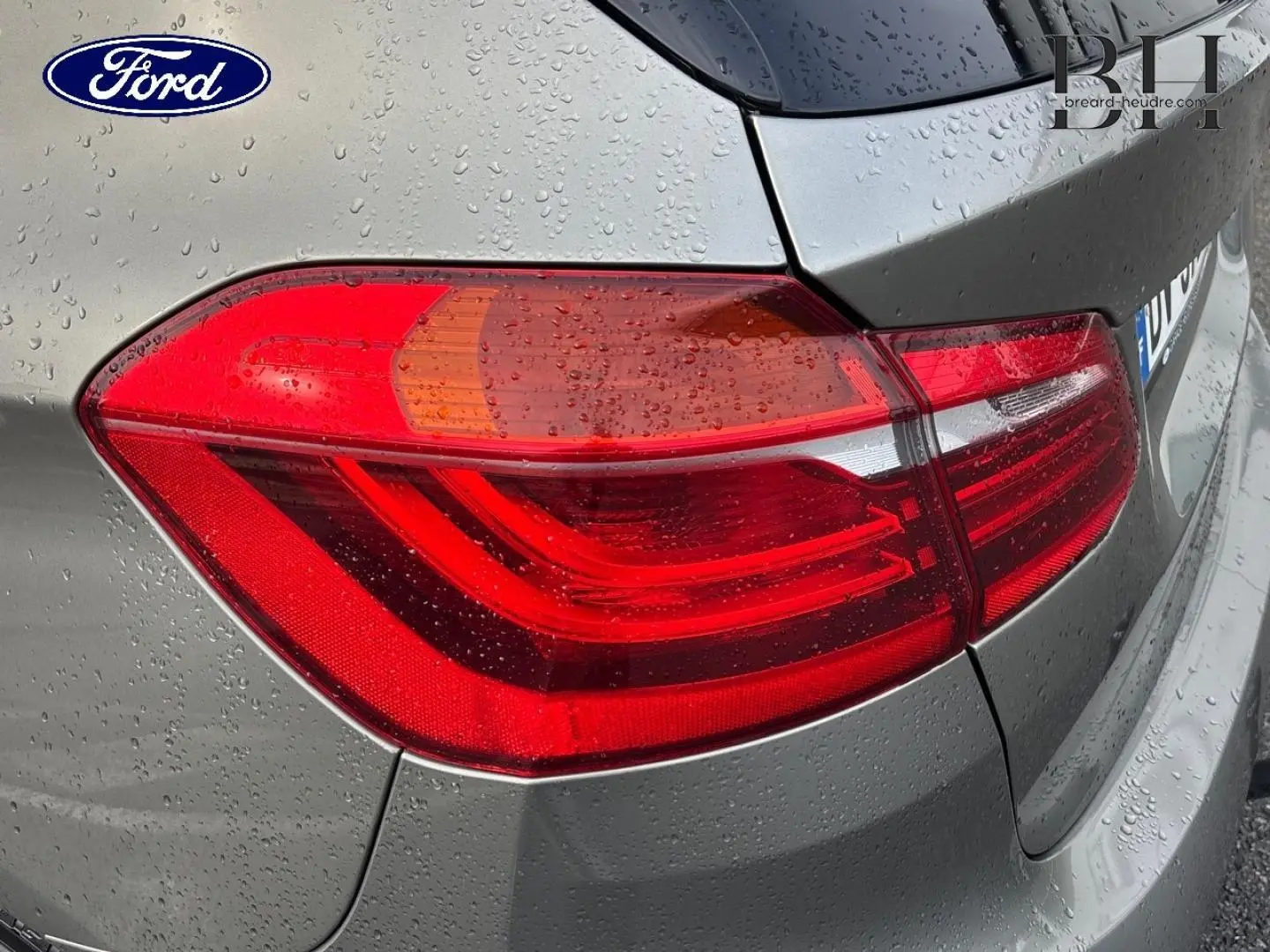 Feu arrière droit de BMW Série 2 Active Tourer 216dA 2015 en Platinumsilber avec gouttes de pluie visibles.