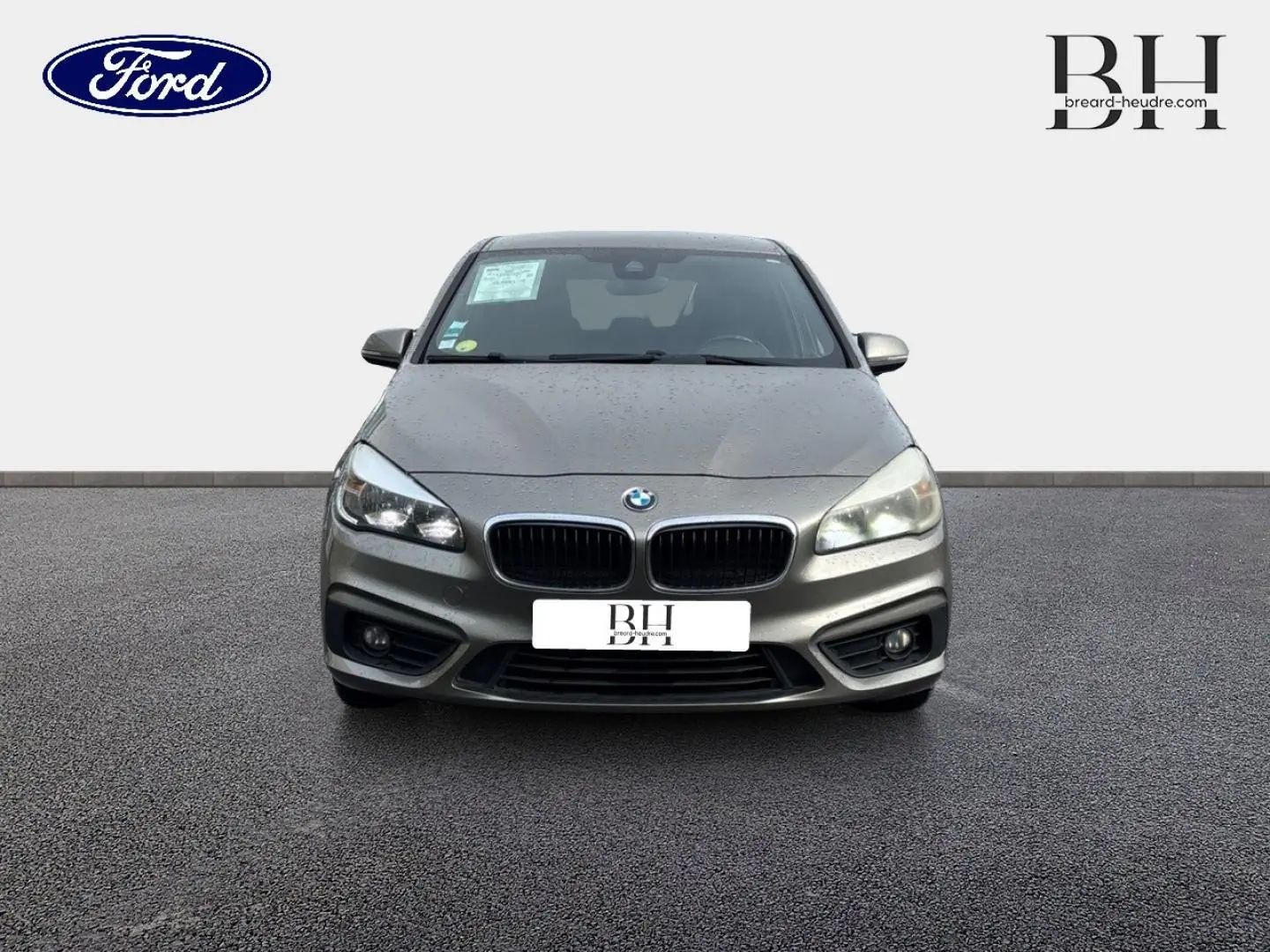 Vue avant d'une BMW Série 2 Active Tourer 216dA platinumsilber avec calandre double haricot et phares allumés.