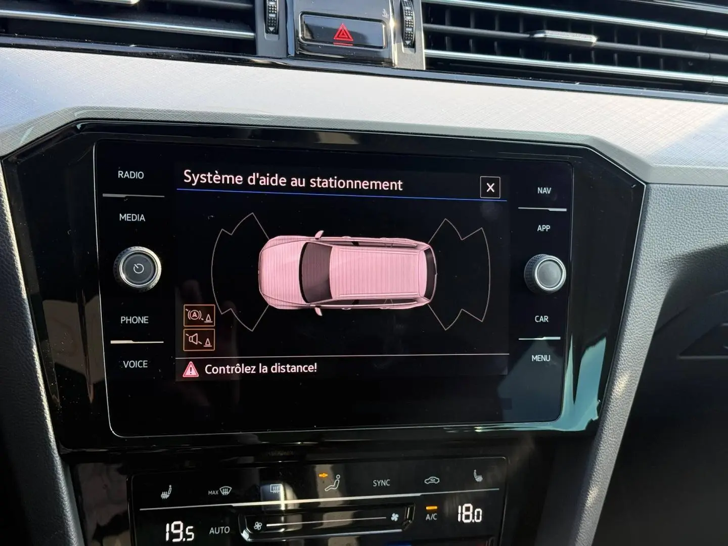 Écran tactile central affichant l’aide au stationnement dans l’habitacle noir de la Volkswagen Passat SW 2023.
