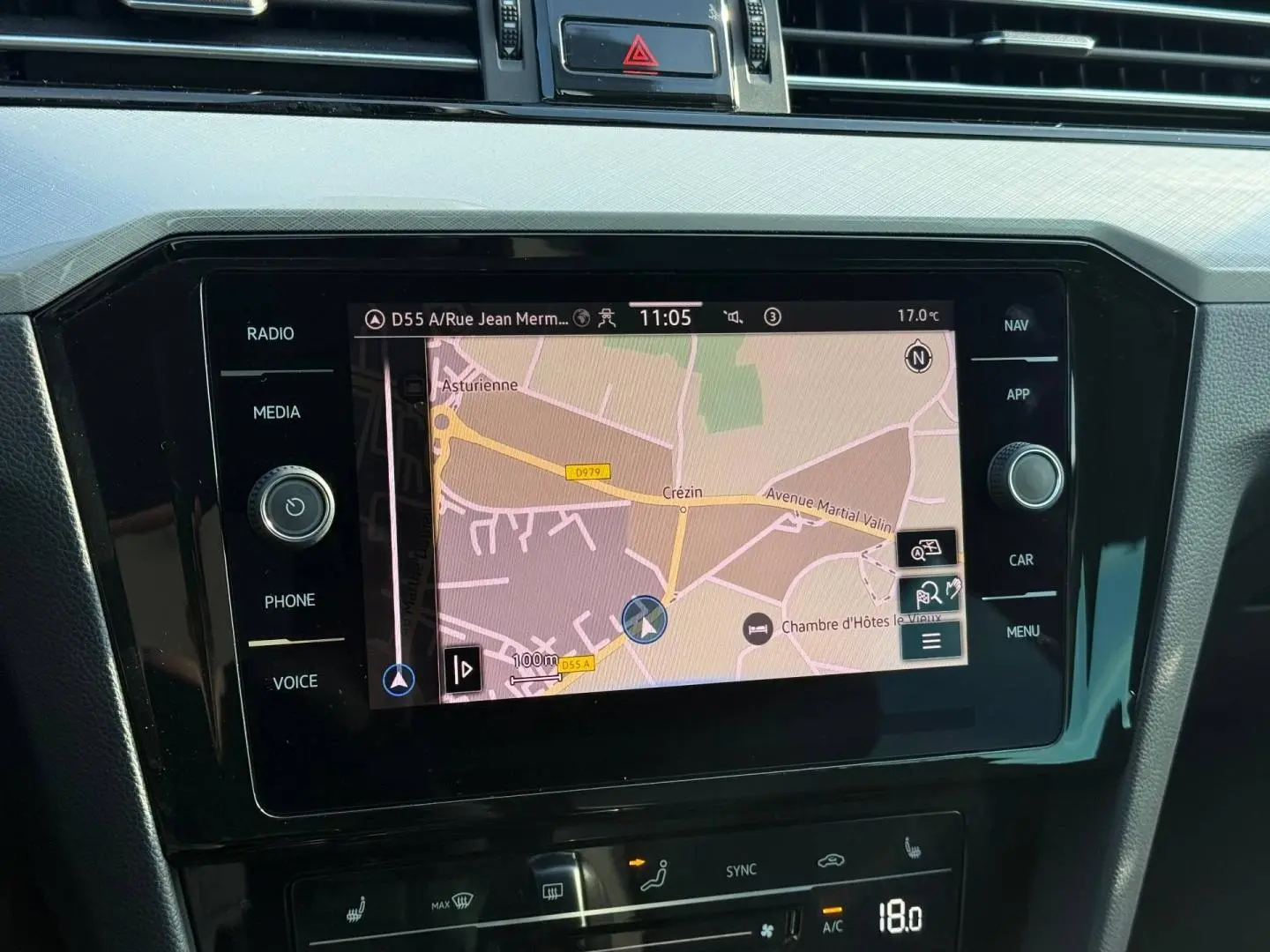 Vue rapprochée de l'écran tactile central du système de navigation de la Volkswagen Passat SW 2023, avec commandes autour.