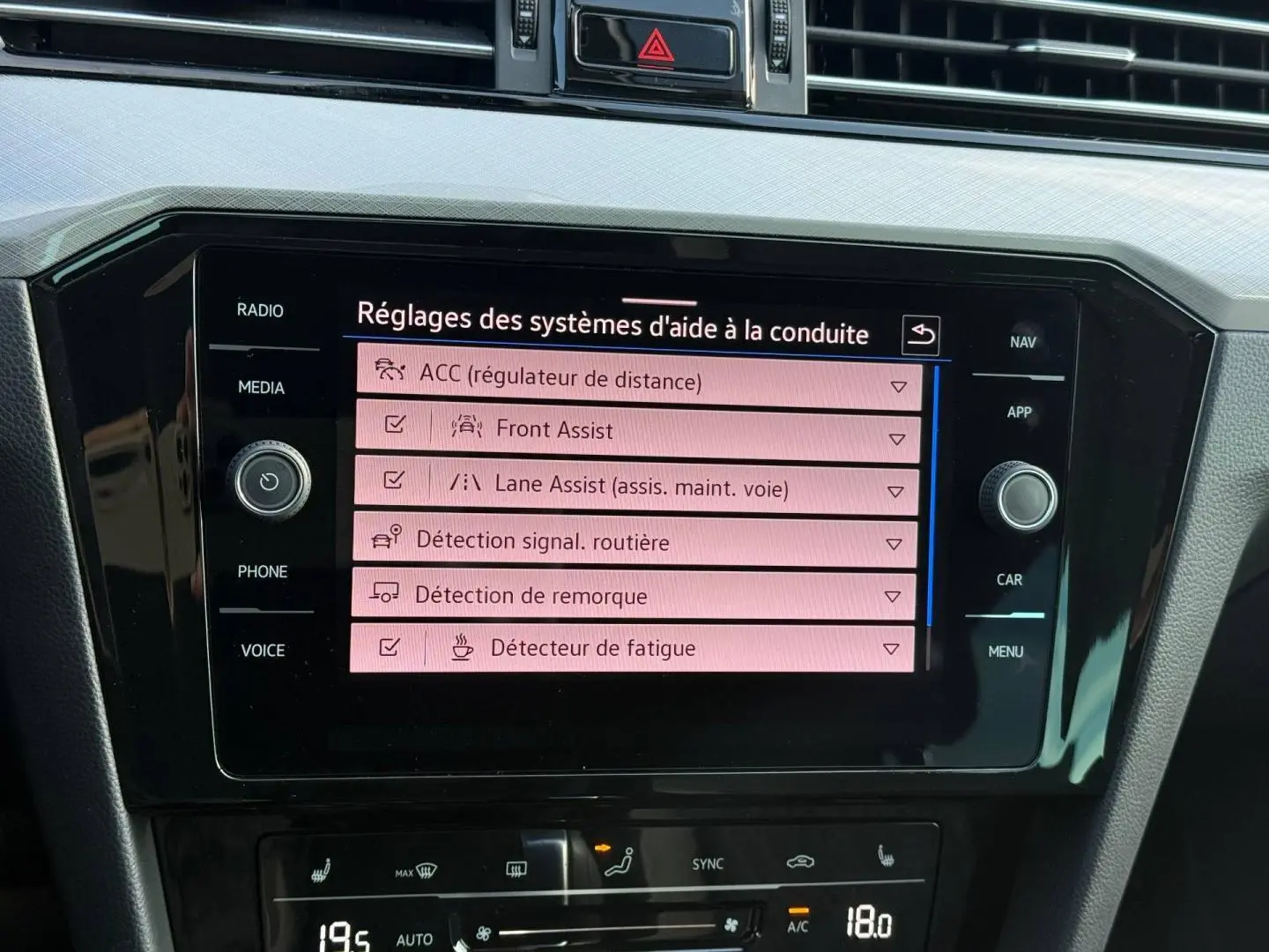 Écran tactile central de la Volkswagen Passat SW noir nacré, affichant les réglages d’aide à la conduite.
