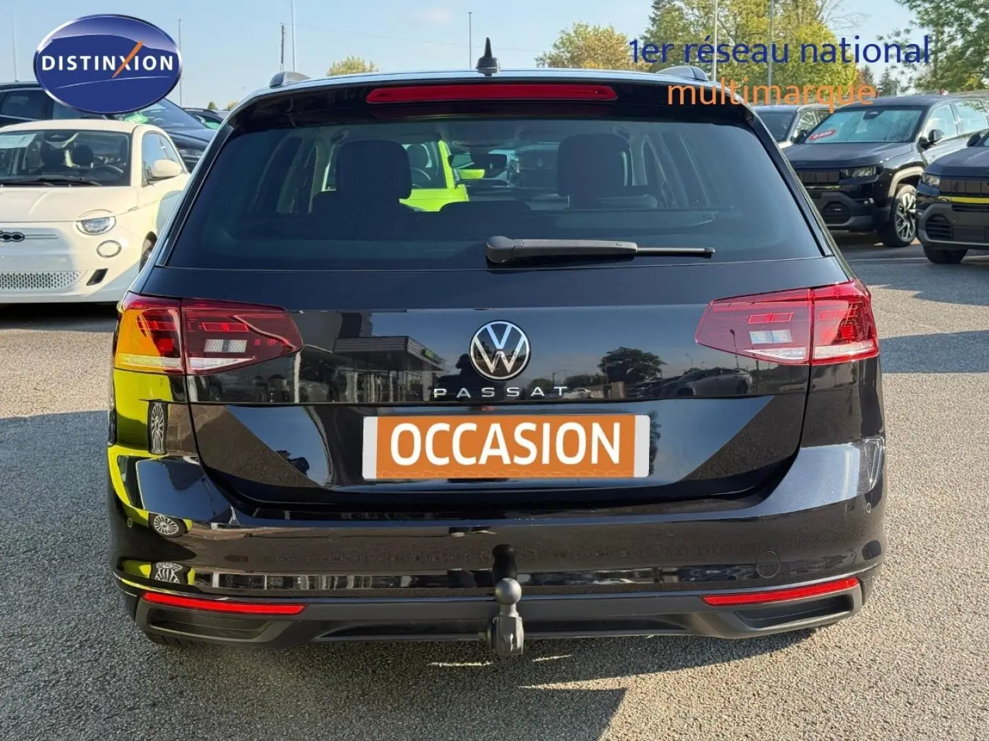 Vue arrière d'une Volkswagen Passat SW noire intense nacrée avec attelage et feux arrière LED visibles.
