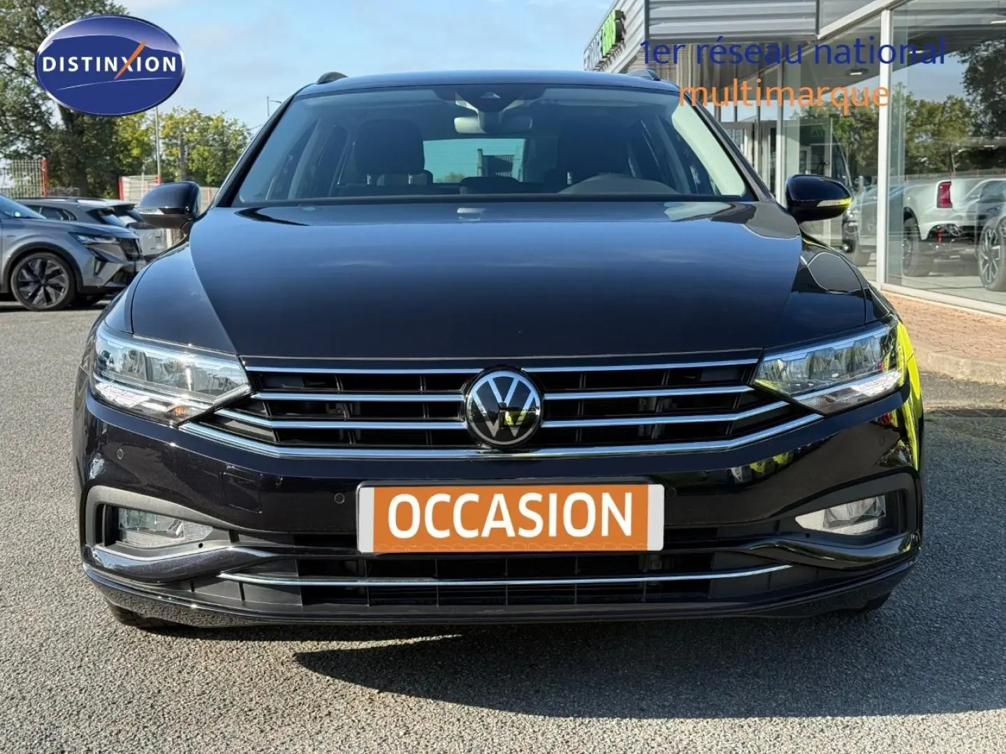 Vue frontale d'une Volkswagen Passat SW noire intense nacrée avec calandre chromée et feux LED, en extérieur.