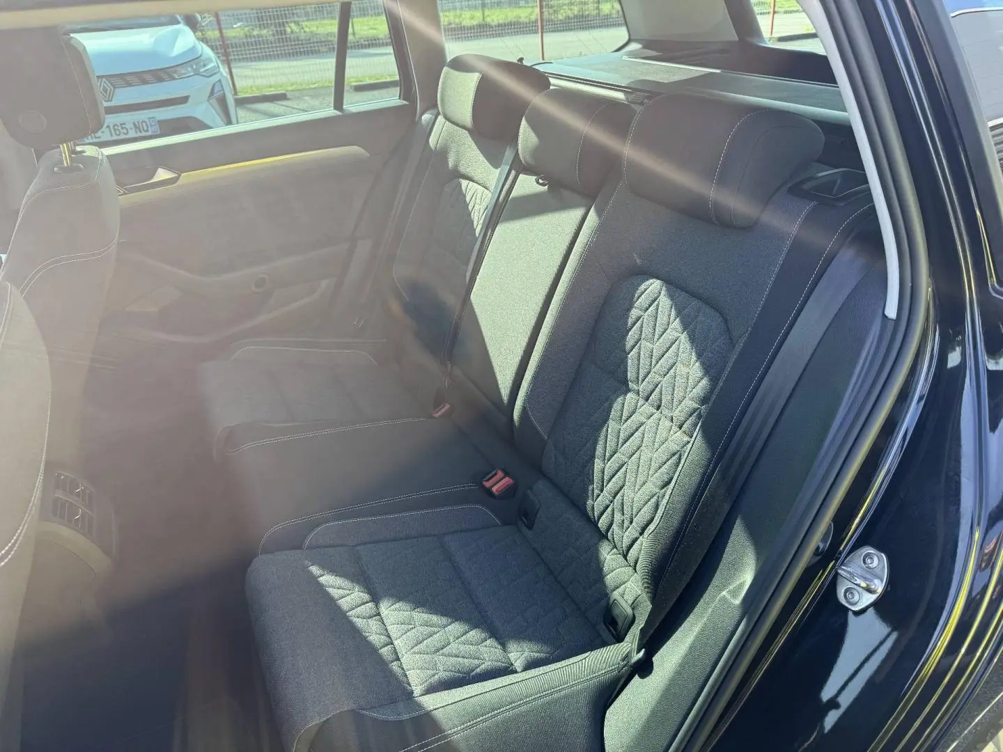 Vue côté droit de la banquette arrière en tissu noir avec surpiqûres blanches dans une Volkswagen Passat SW 2023.