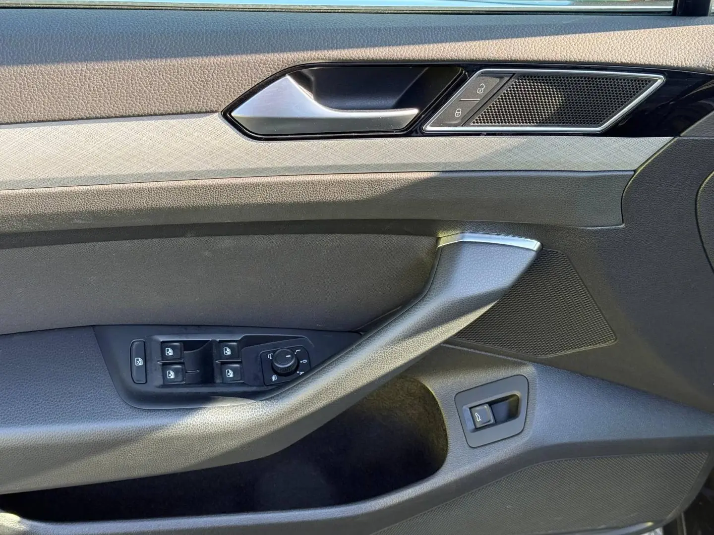 Vue rapprochée de la porte avant gauche de la Volkswagen Passat SW 2023, avec commandes vitres et verrouillage.