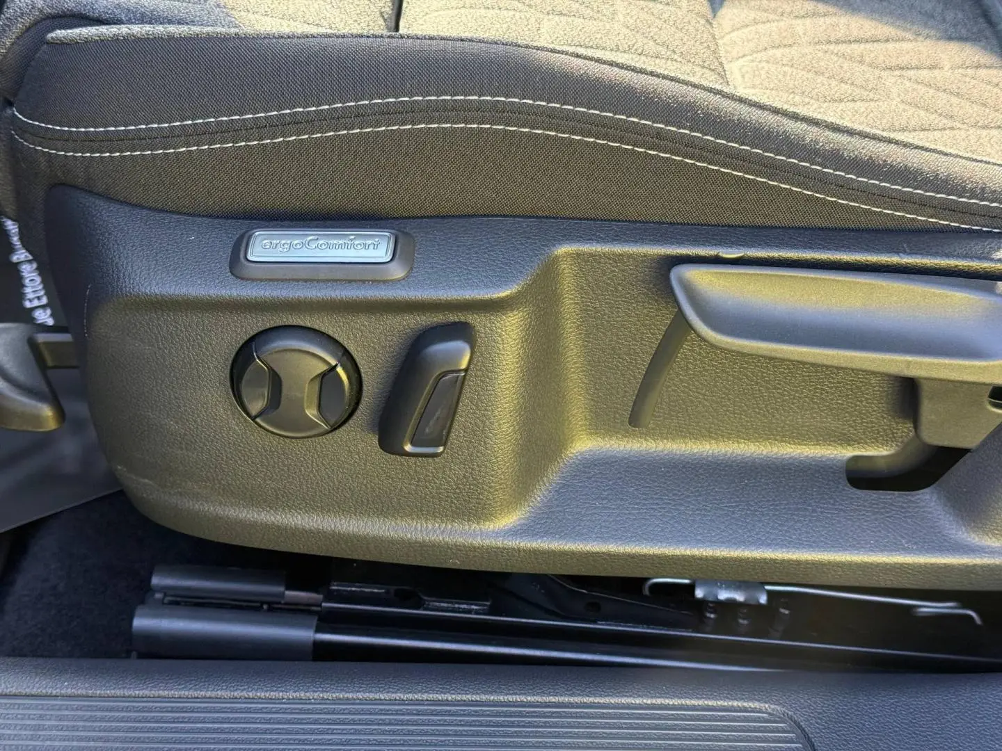 Détail côté gauche du siège avant noir avec commandes de réglage ErgoComfort sur Volkswagen Passat SW 2023.