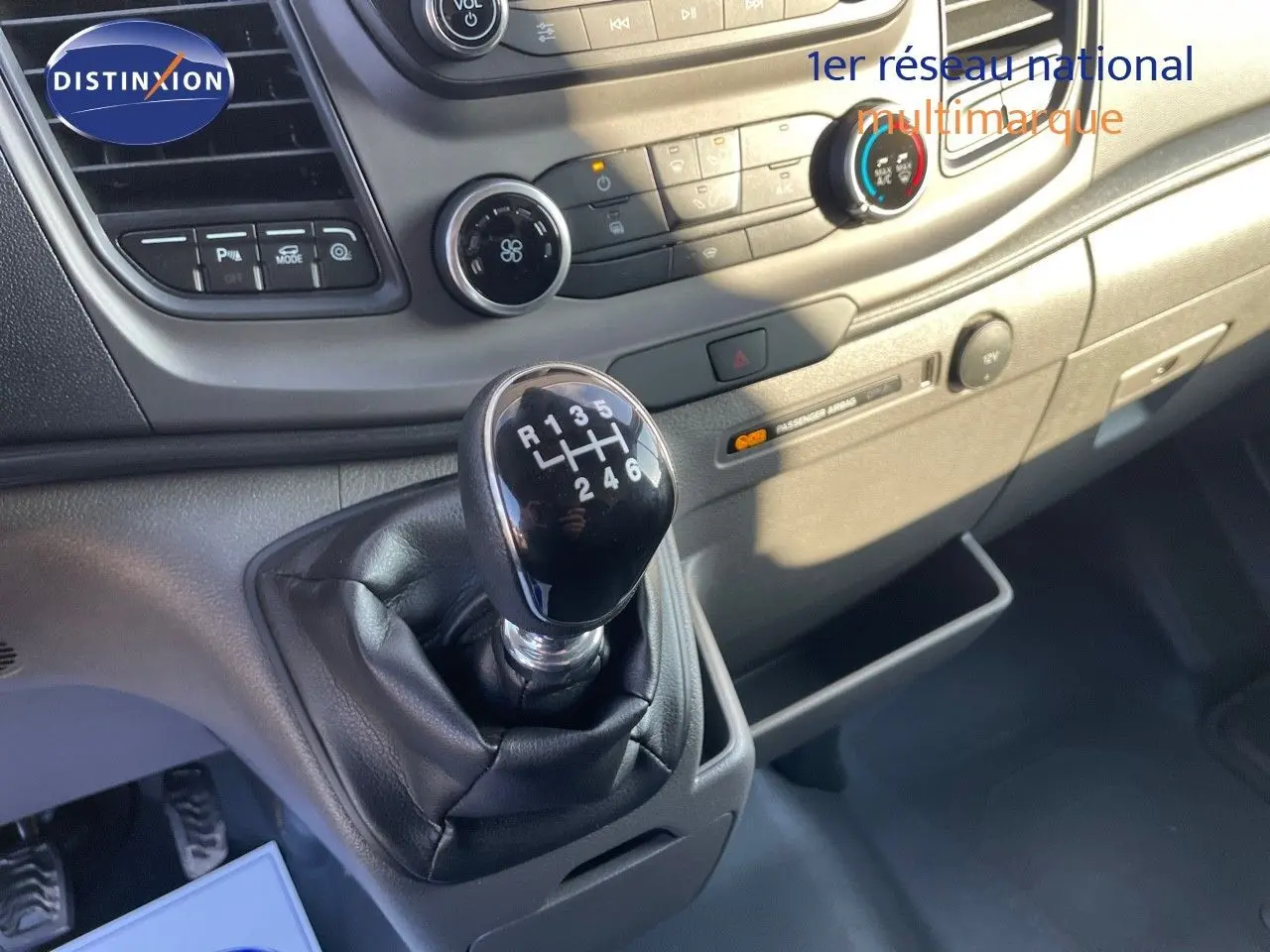 Gros plan sur le levier de vitesses manuel noir et la console centrale du Ford Transit Fourgon blanc 2023.