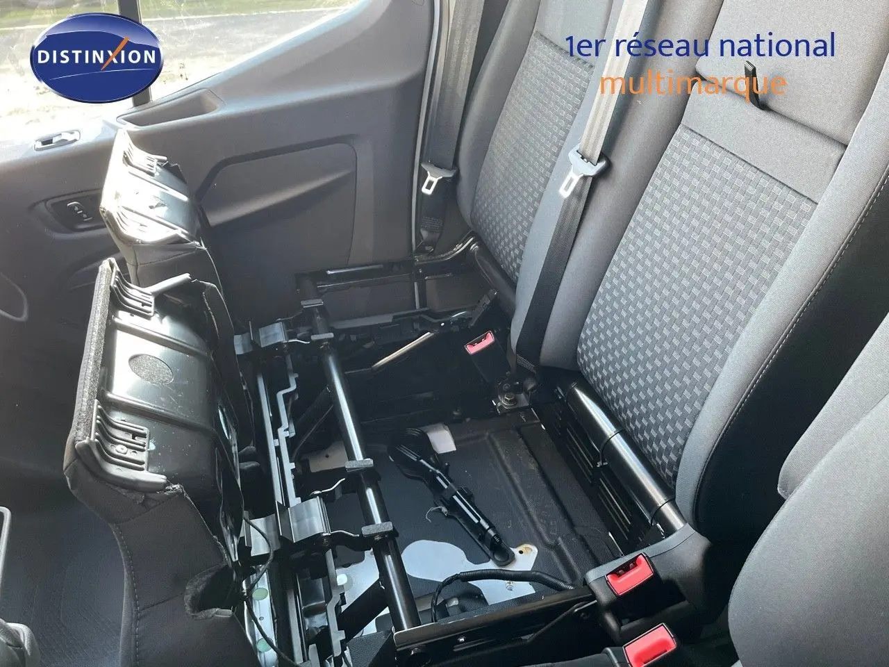 Vue intérieure côté droit montrant la banquette arrière grise et noire du Ford Transit Fourgon blanc 2023 avec siège relevé.