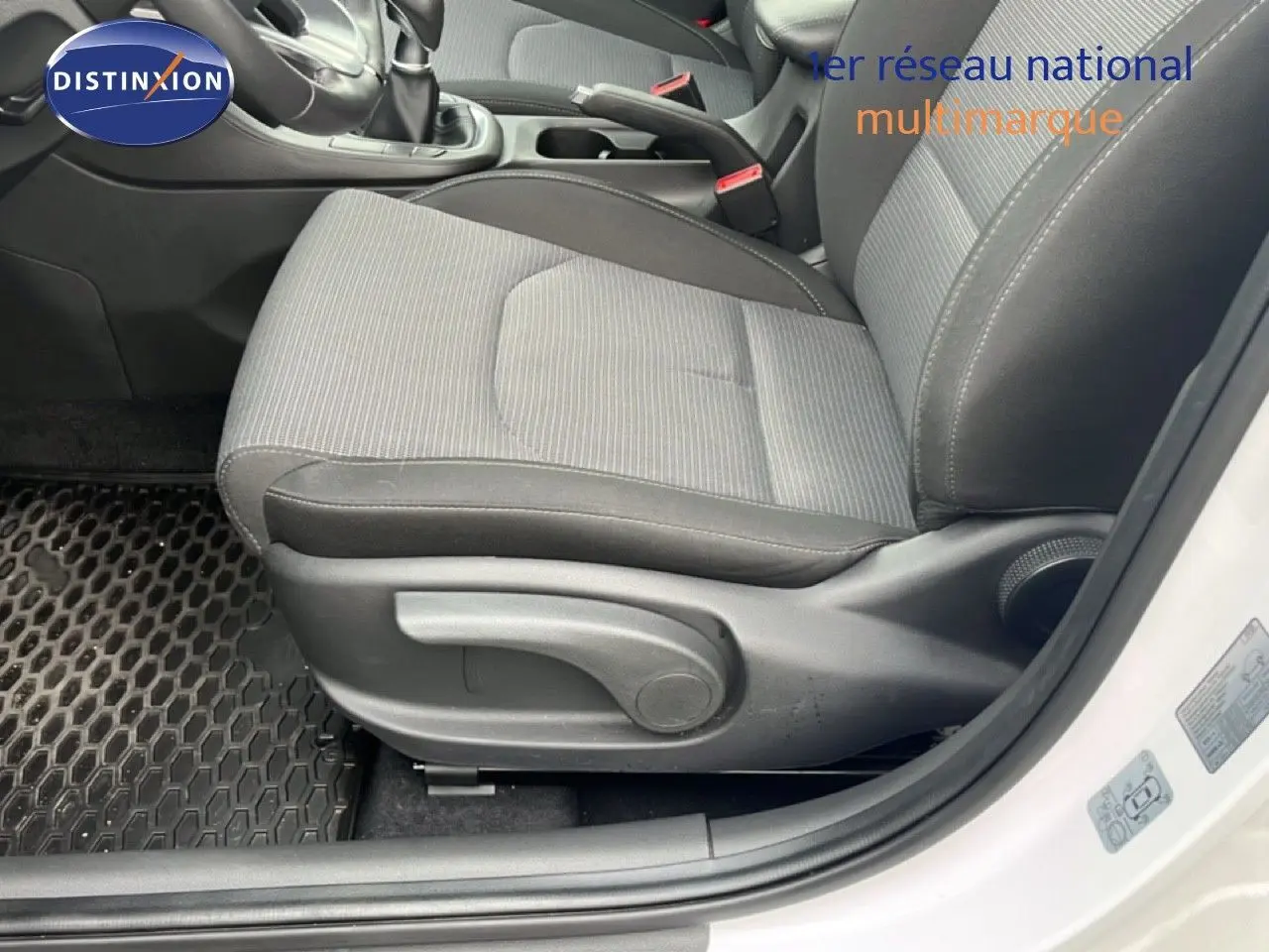 Vue rapprochée du siège avant droit gris et noir de la Hyundai i30 blanc nacré, avec levier de frein à main visible.