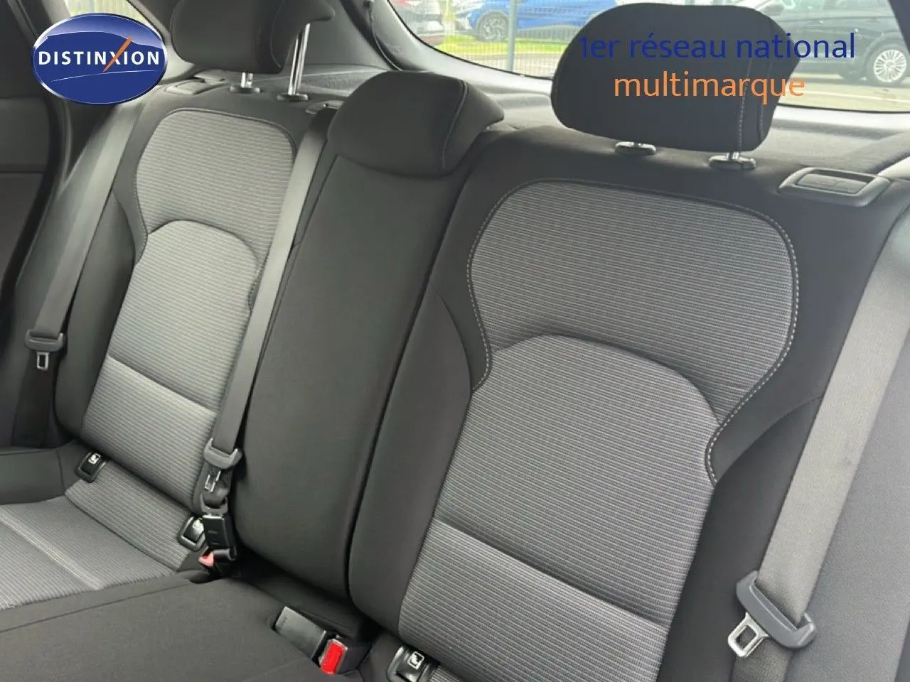 Vue intérieure montrant les sièges arrière en tissu gris et noir de la Hyundai i30 2023, avec ceintures de sécurité visibles.