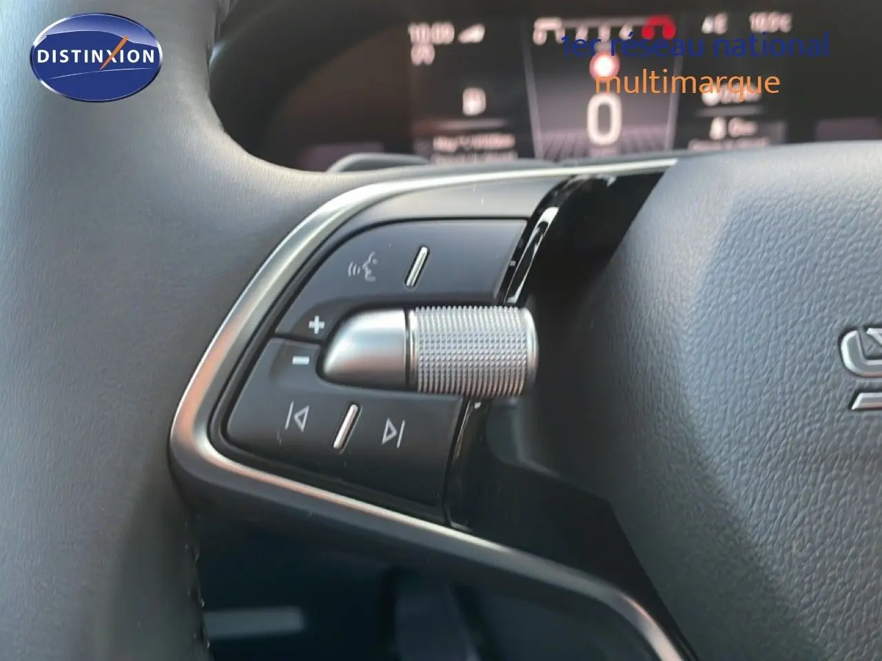 Gros plan sur la commande au volant du Skoda Kamiq gris argent, mettant en valeur les boutons de réglage audio et la molette.