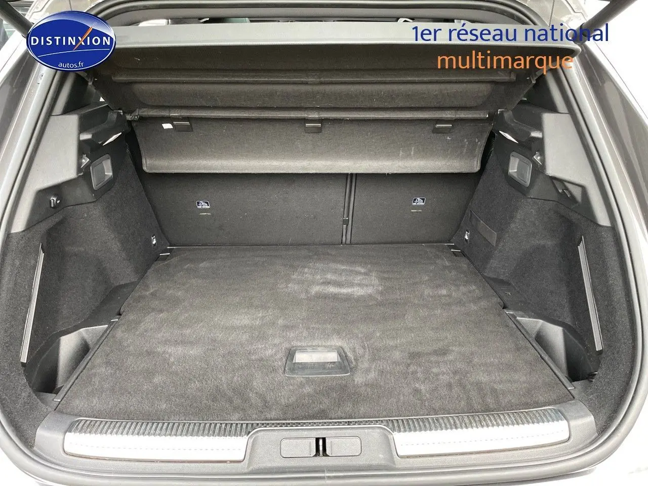 Coffre ouvert du DS7 Crossback gris platinium, vue de l'arrière montrant un espace de chargement spacieux et bien fini.