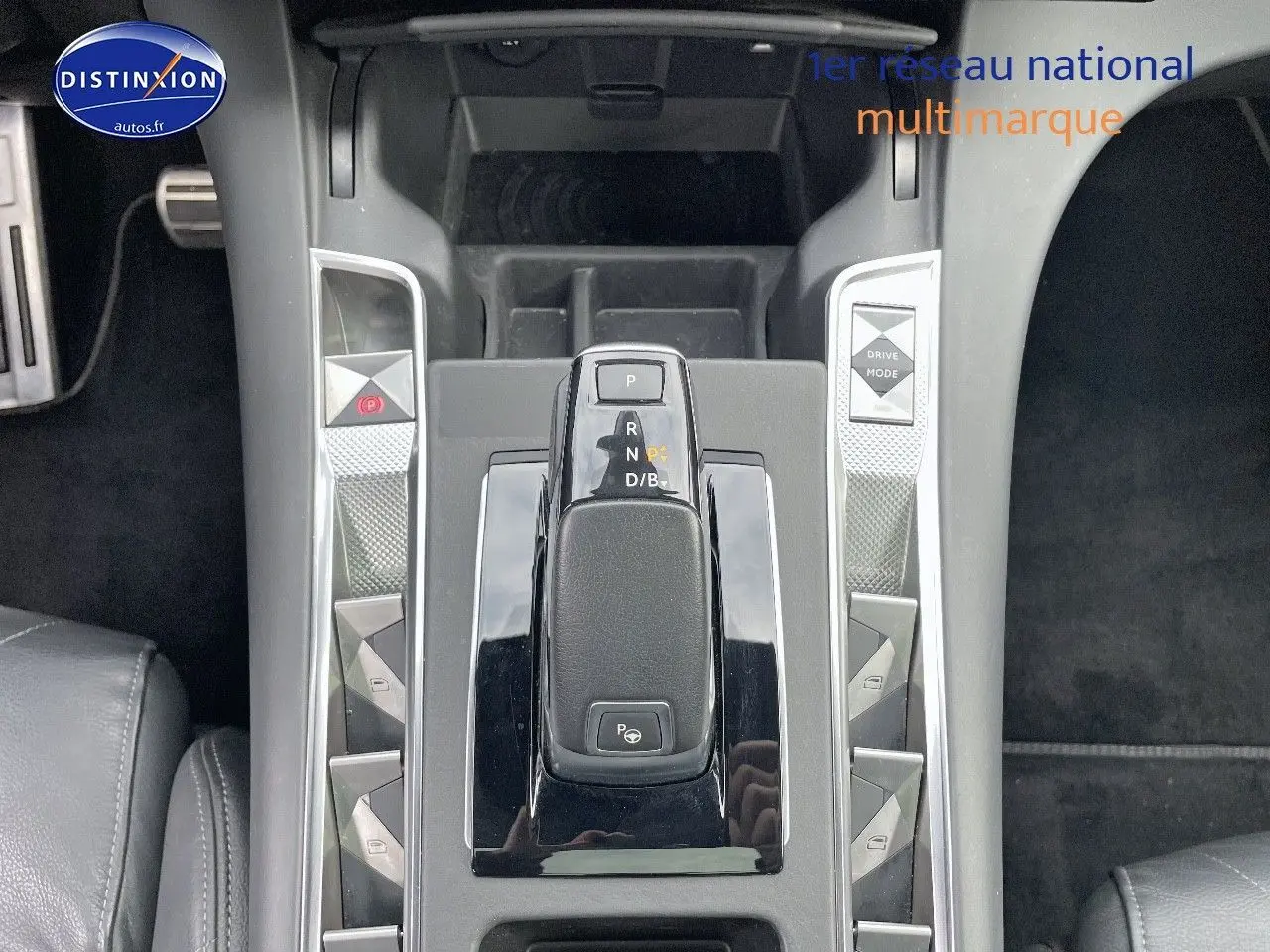 Vue plongeante sur la console centrale du DS7 Crossback E-TENSE 2021, avec levier de vitesses et boutons argentés.