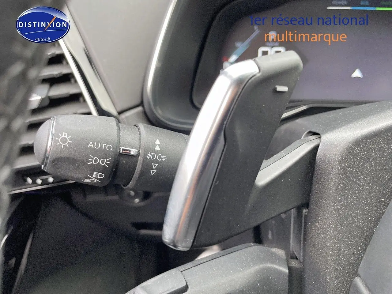 Gros plan sur la commande des phares et la palette de changement de vitesse du DS7 Crossback gris platinium intérieur.