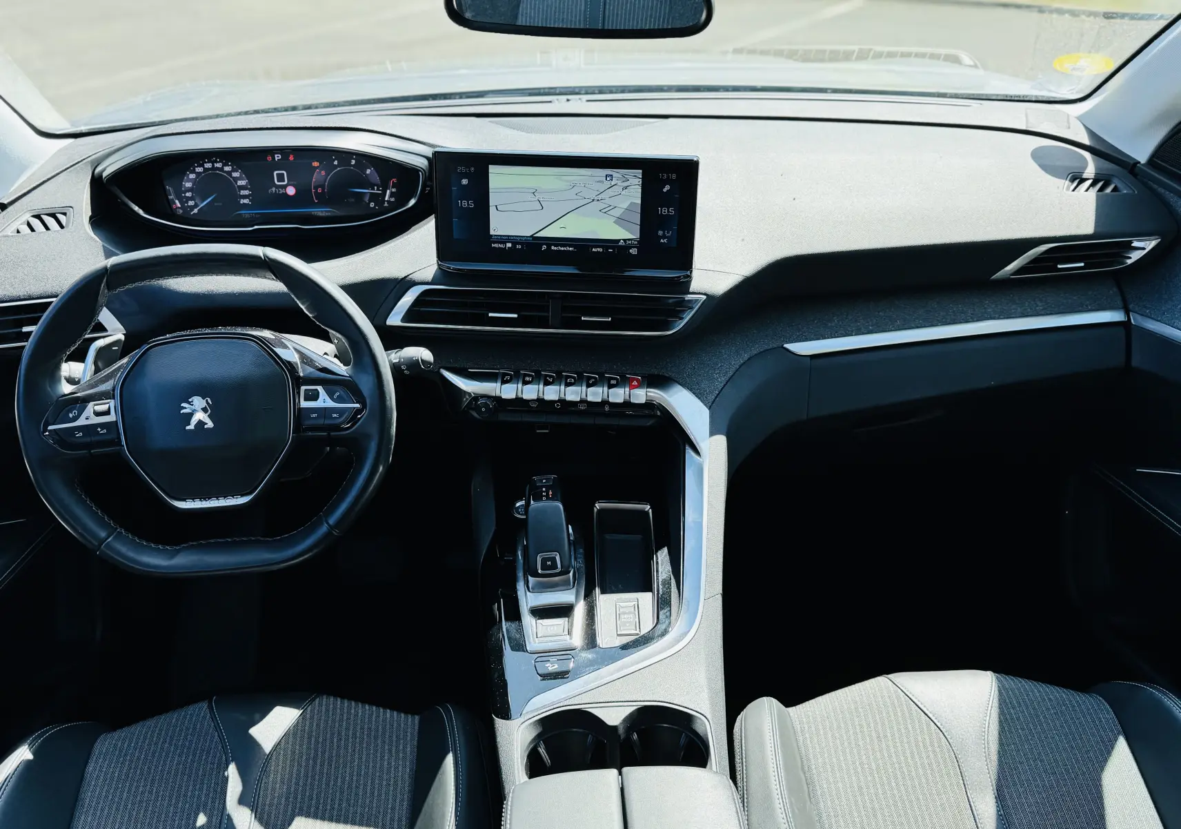 Vue intérieure avant du Peugeot 3008 2021, tableau de bord moderne avec écran tactile et volant compact noir.