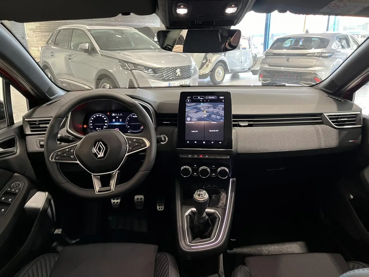 Vue intérieure avant de la Renault Clio 1.0 Tce 90 Esprit Alpine 2024 avec tableau de bord moderne et boîte manuelle.