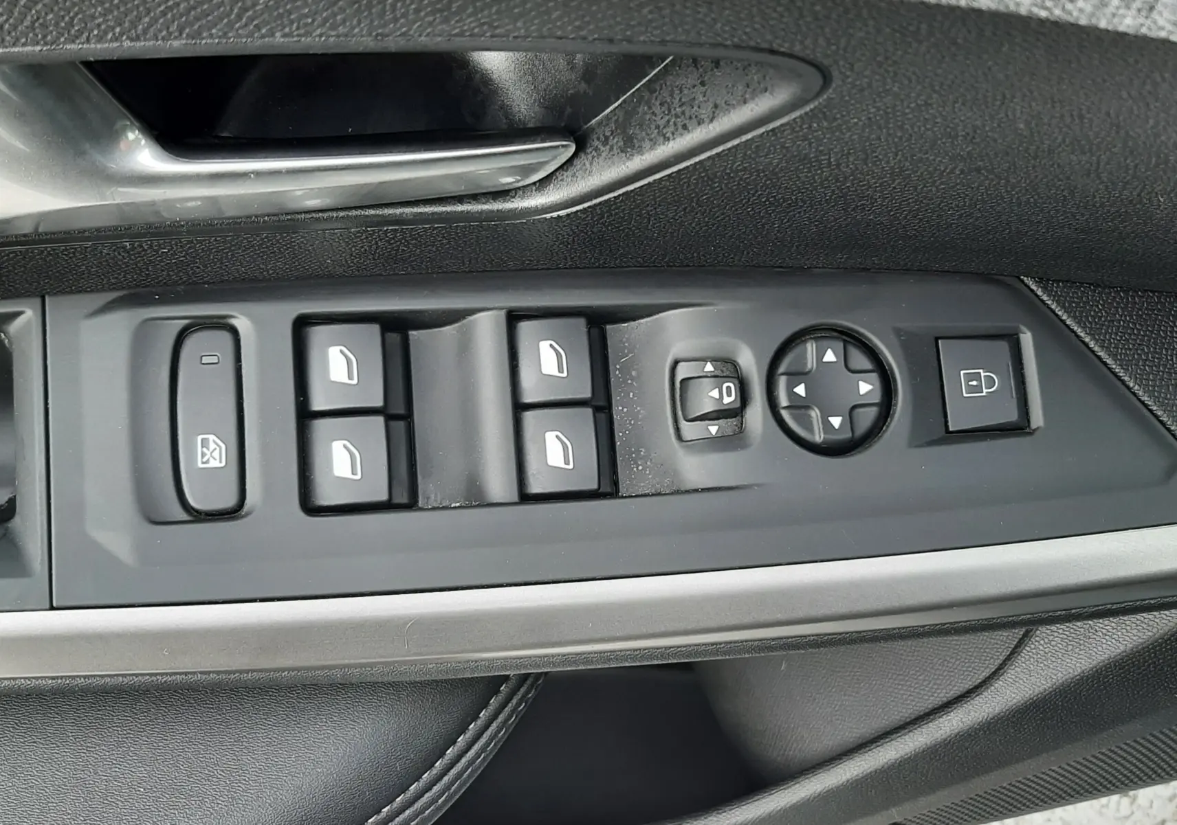 Vue rapprochée des commandes de lève-vitres et rétroviseurs sur la porte côté gauche d’un Peugeot 3008 bleu Ingara.