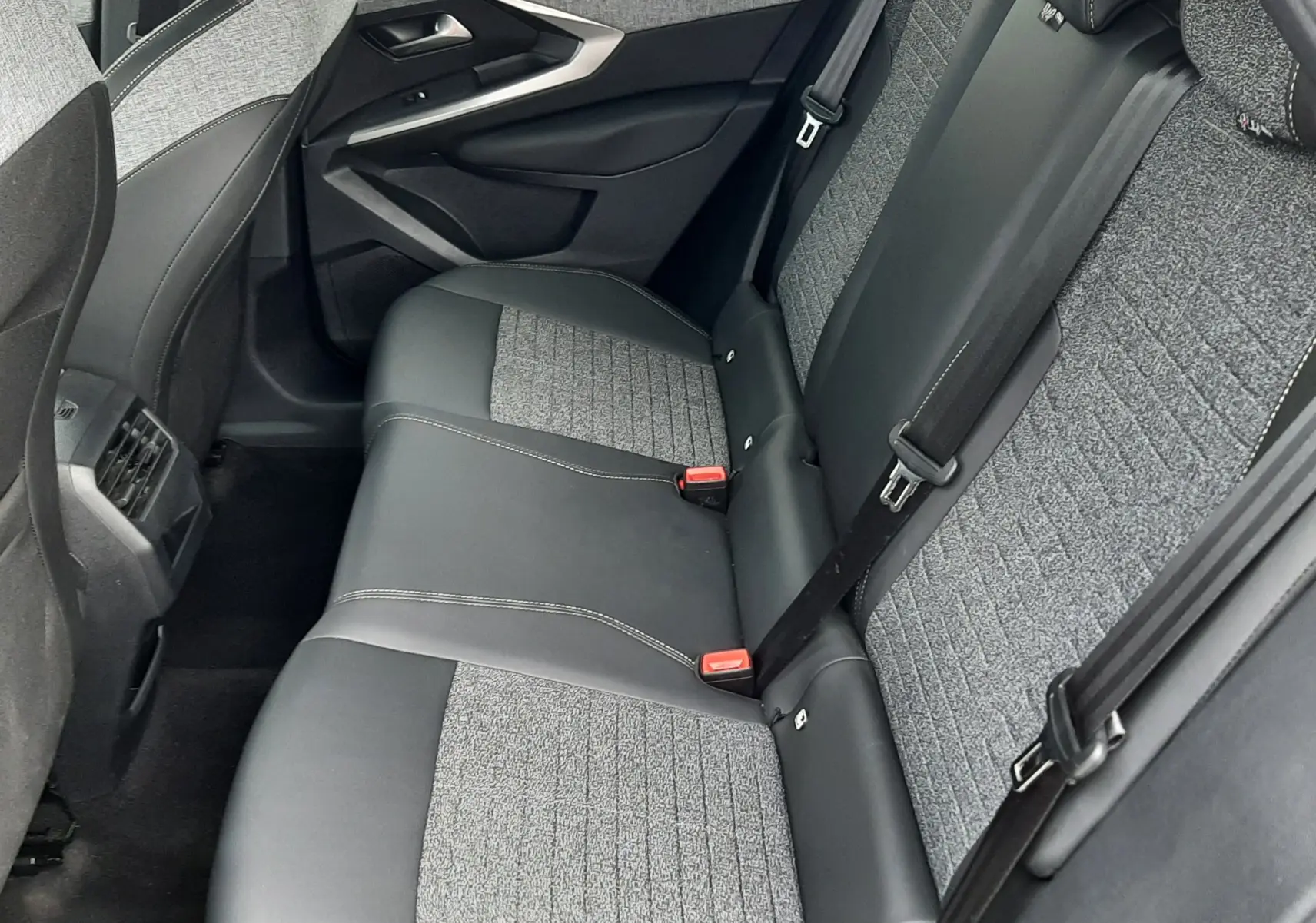 Vue intérieure côté droit des sièges arrière gris noir du Peugeot 3008 III HYBRID 145 ALLURE e-DSC6 2025.
