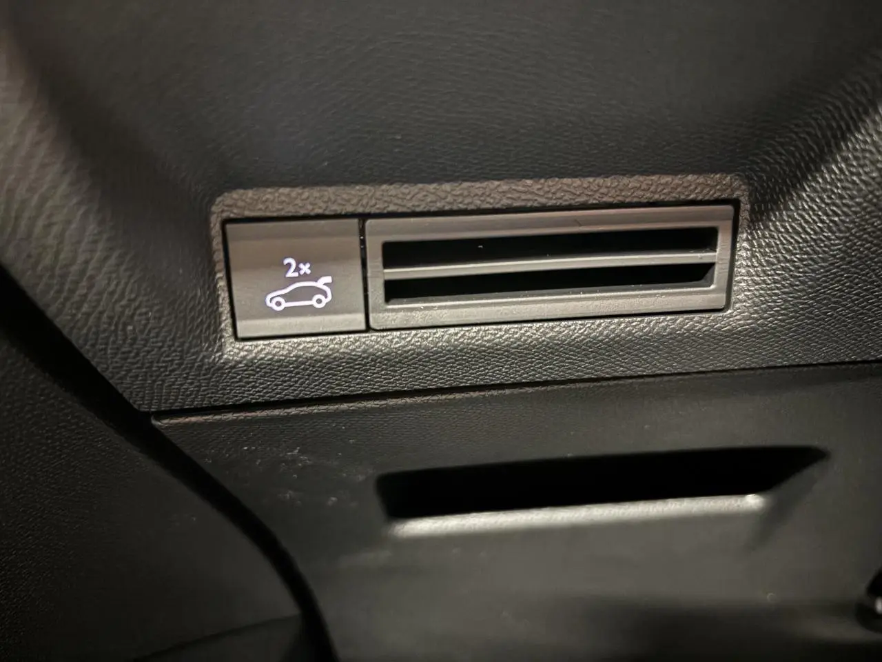 Détail du bouton d'ouverture du hayon sur console intérieure noire du Peugeot 3008 Gris Artense.