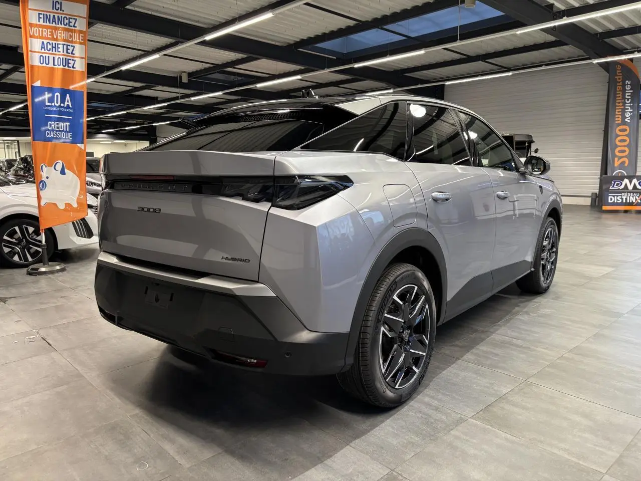 Vue 3/4 arrière droit du Peugeot 3008 Hybrid gris Artense avec feux arrière à griffes LED et jantes alliage 19 pouces.
