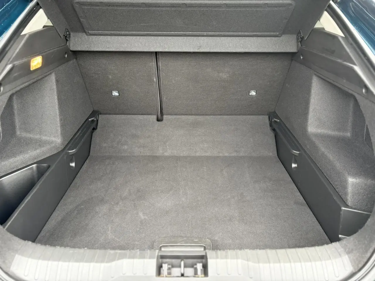 Coffre ouvert vu de face, intérieur spacieux et tapis noir du Renault Arkana TCE 140 EDC MHEV Bleu Zanzibar.