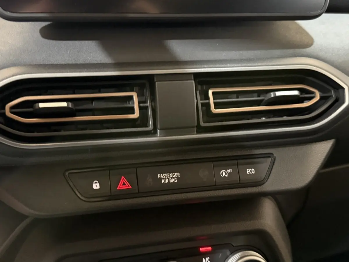 Détail du tableau de bord central de la Dacia Sandero Extreme+ 2024, montrant les aérateurs et les boutons de sécurité.