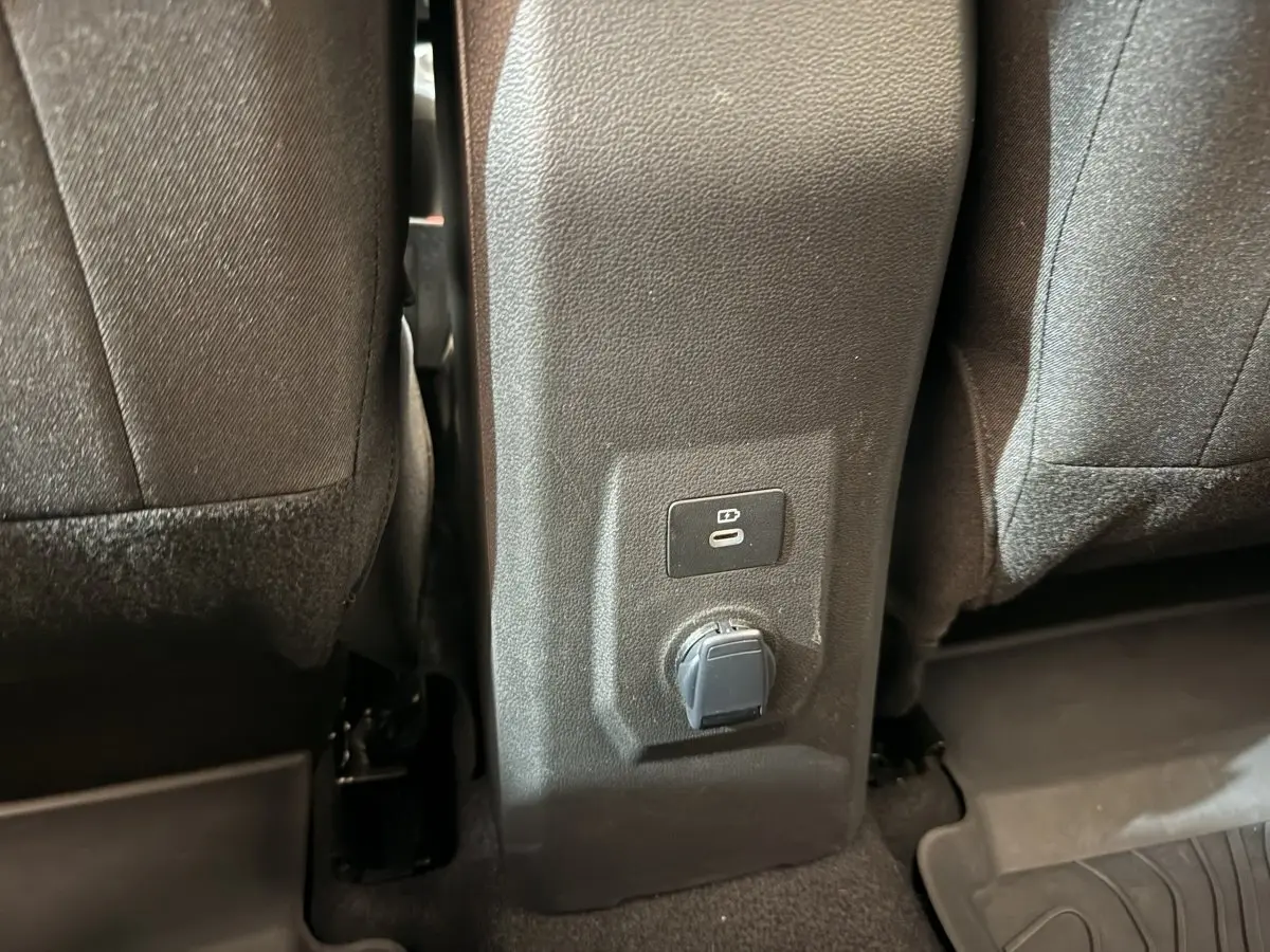 Prise USB et prise 12V entre les sièges arrière d'une Dacia Sandero Extreme+ TCe 110 verte, vue intérieure rapprochée.