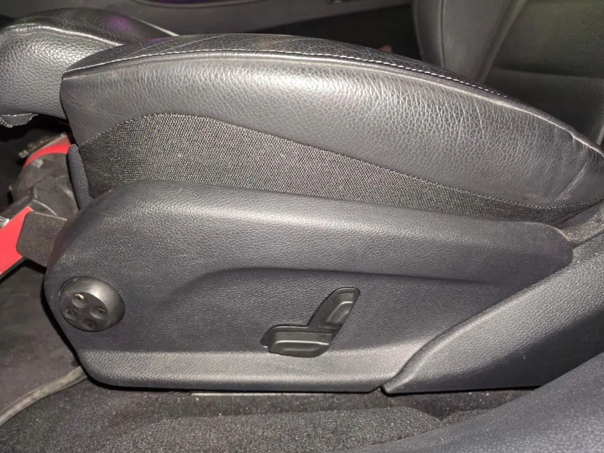 Détail du réglage électrique du siège avant en cuir noir dans un Mercedes Classe E Break gris 2020 AMG Line.