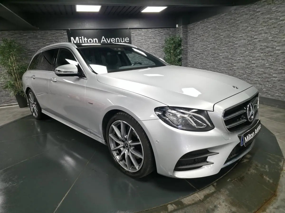 Mercedes Classe E Break gris métallisé en 3/4 avant droit avec jantes AMG 19 pouces et vitres teintées.
