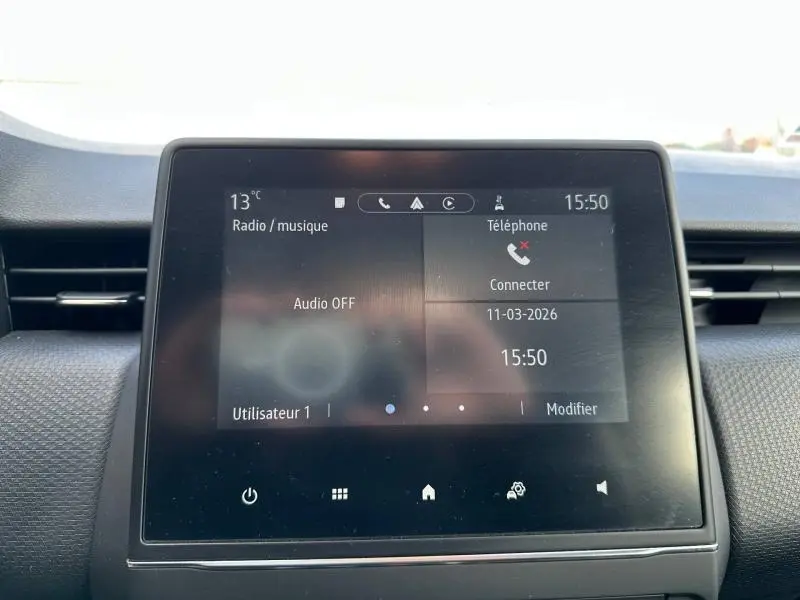 Écran tactile central du tableau de bord de la Renault Clio 2023, affichant les options radio et téléphone, intérieur gris.