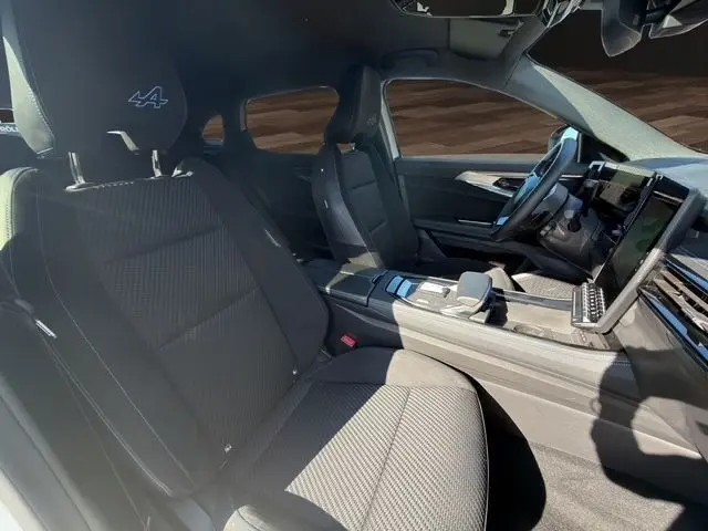 Vue intérieure côté droit du Renault Austral esprit Alpine 2025, sièges noirs avec logo Alpine brodé et tableau de bord digital.