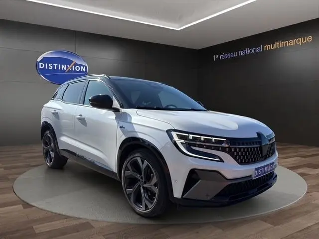 Vue 3/4 avant d’un Renault Austral blanc esprit Alpine avec jantes noires et calandre distinctive en concession.