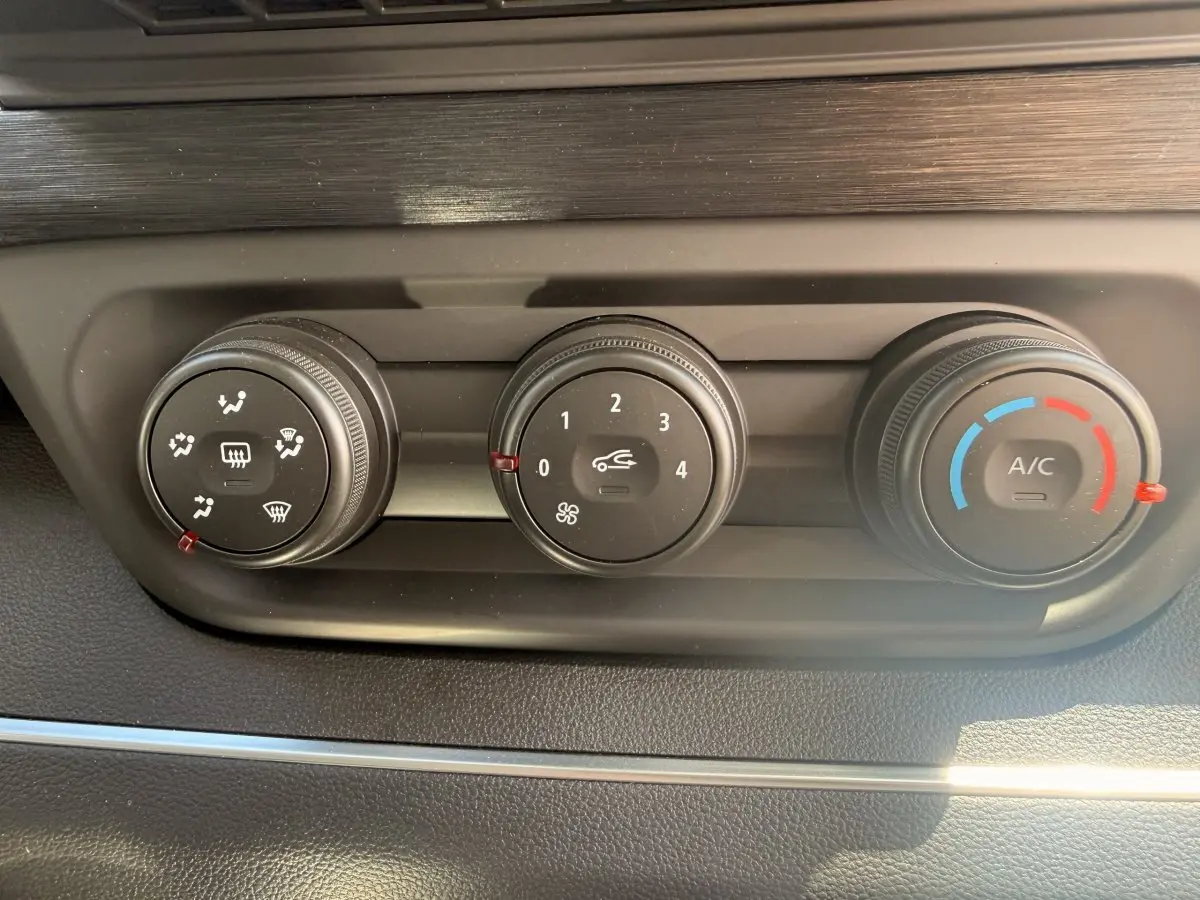 Gros plan sur les commandes de climatisation du Renault Trafic Fourgon blanc, avec réglages de ventilation, air recyclé et température.