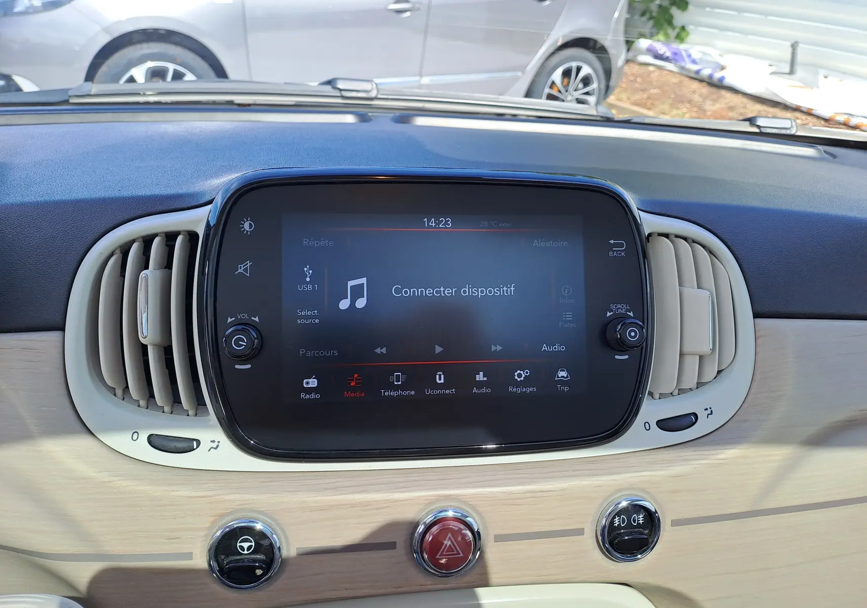 Tableau de bord clair de Fiat 500 1.0 Hybrid 2022 avec écran tactile central et aérateurs ovales beige.