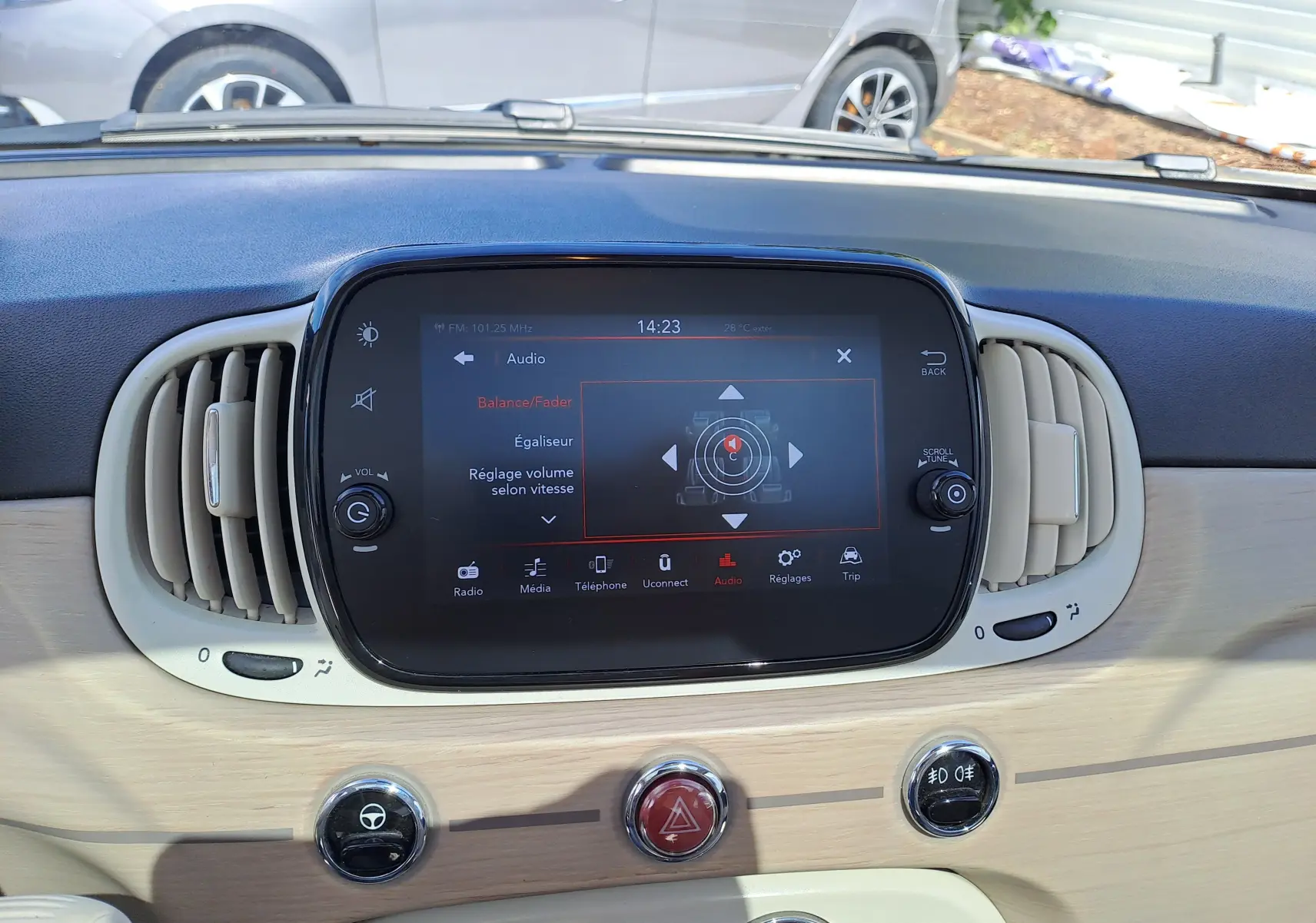 Tableau de bord clair et écran tactile central de la Fiat 500 blanche, vue intérieure frontale détaillée.