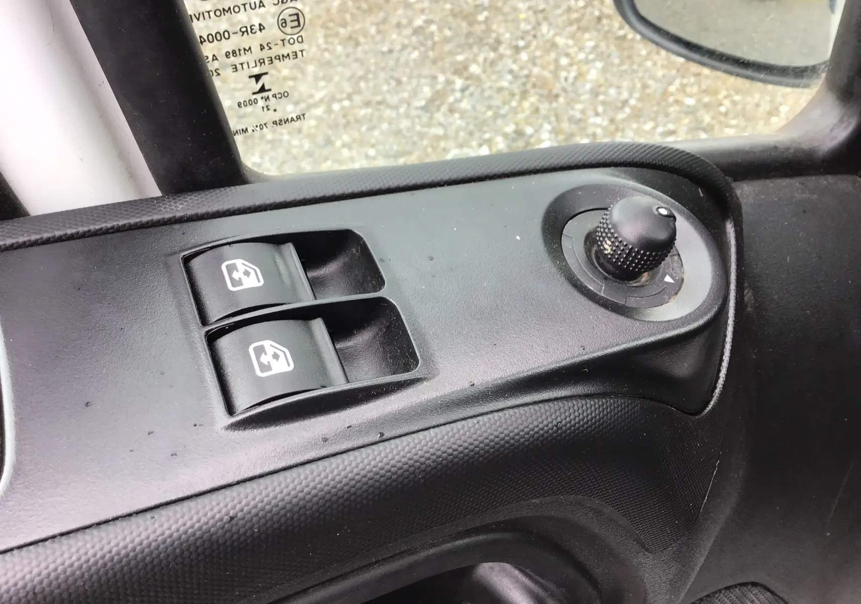 Gros plan sur les commandes de lève-vitres et réglage des rétroviseurs côté conducteur d'un Iveco Daily blanc de 2021.