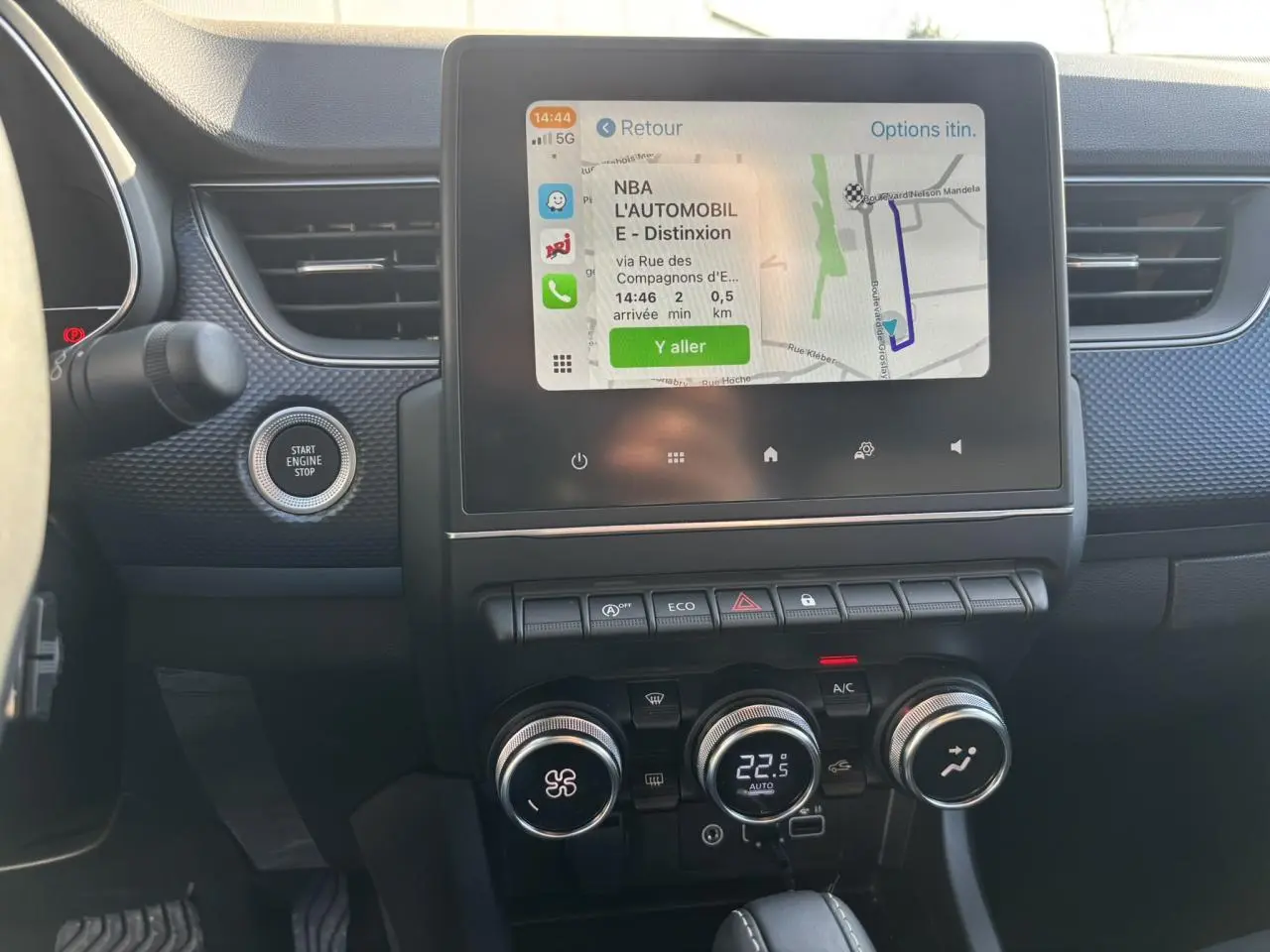 Vue intérieure centrée sur la console centrale du Renault Arkana 2025 avec écran tactile GPS et commandes climatisation.