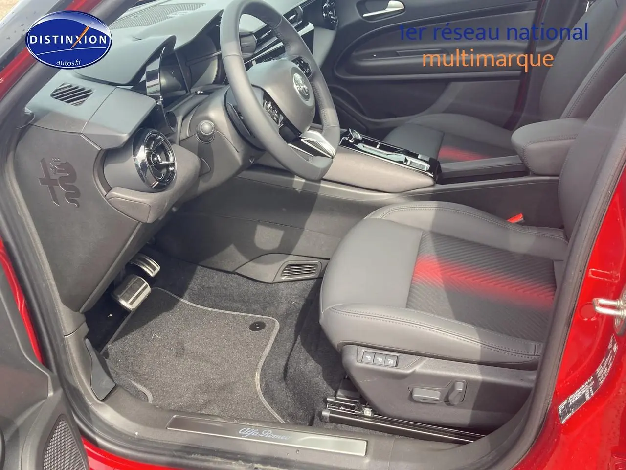 Intérieur côté conducteur d'Alfa Romeo Junior 1.2 hybride rouge/noir, siège électrique et volant multifonctions.