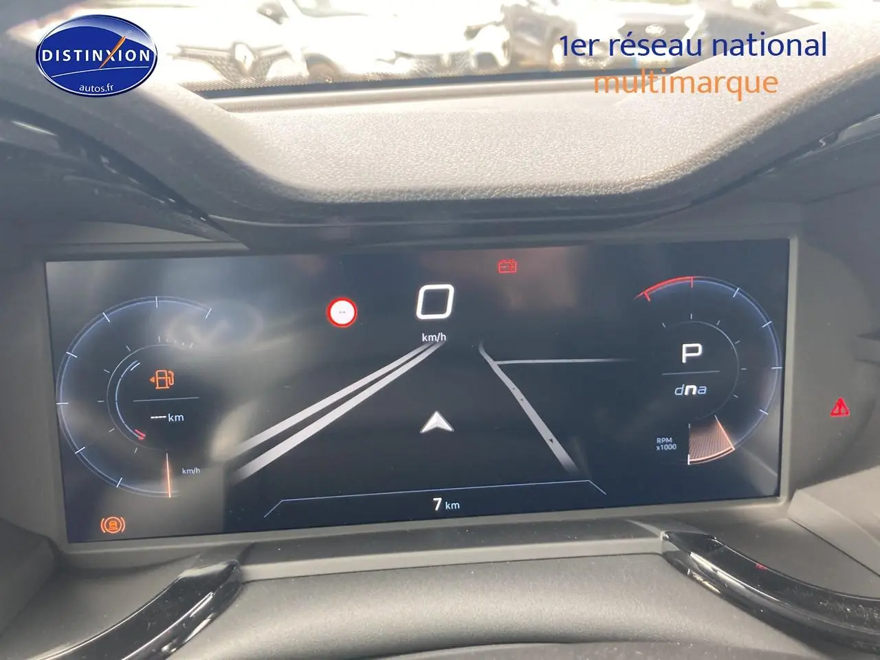 Tableau de bord numérique de l'Alfa Romeo Junior 1.2 hybride, affichage vitesse et mode de conduite, vue frontale rapprochée.