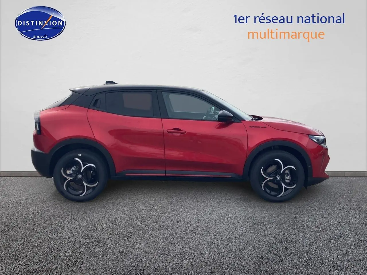 Profil gauche de l'Alfa Romeo Junior 1.2 hybride 2026 rouge et noir avec jantes alliage et vitres teintées.