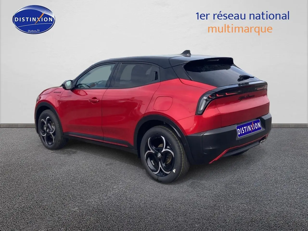 Vue 3/4 arrière droite de l'Alfa Romeo Junior 1.2 hybride rouge et noir avec jantes alliage et toit noir.