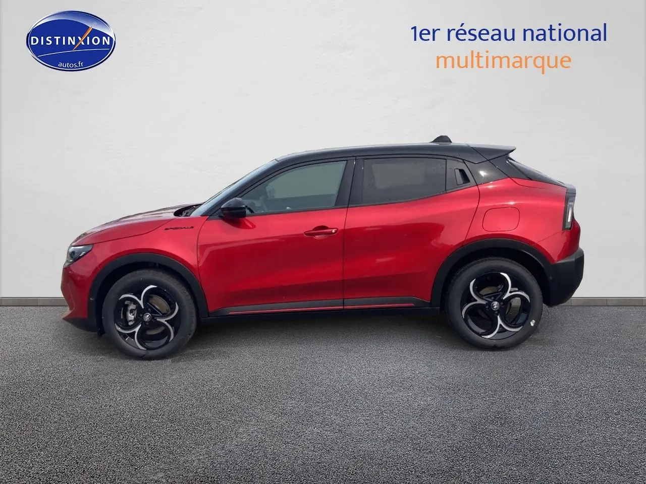 Profil droit de l'Alfa Romeo Junior 1.2 hybride 2026 rouge et noir avec jantes alliage et toit noir contrasté.