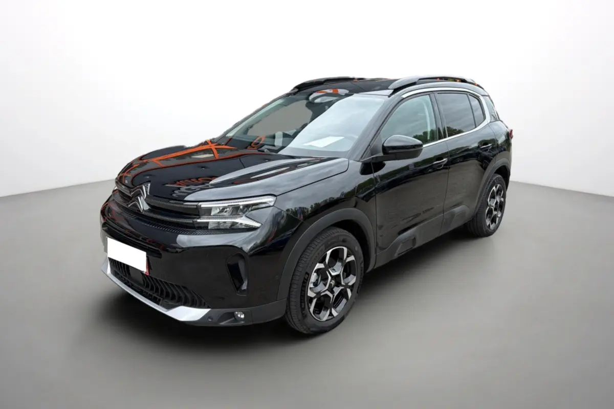 Citroën C5 Aircross noir métallisé vue 3/4 avant droit avec jantes alu et barres de toit visibles.