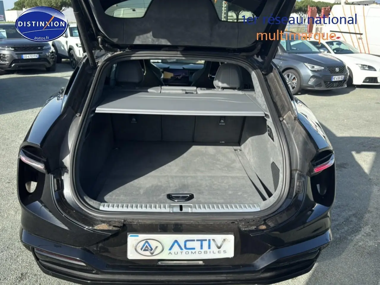 Coffre ouvert vu de l'arrière d'une Lotus Eletre noire 612ch électrique, montrant l'espace de chargement vide.