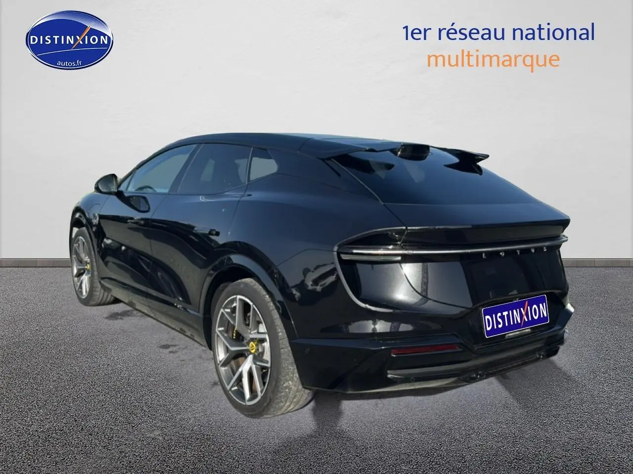 Vue 3/4 arrière droite d'une Lotus Eletre noire 2023 avec jantes alu et feux arrière LED continus.