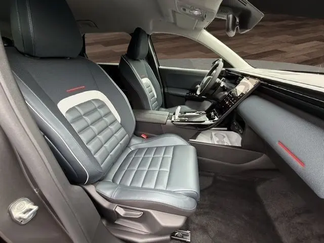 Vue intérieure côté gauche du poste de conduite de la Citroën C5 Hybride 145ch auto MAX avec sièges cuir gris et tableau de bord moderne.