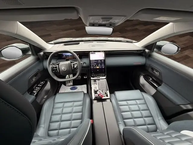 Vue intérieure avant de la Citroën C5 Hybride 2026, sièges cuir gris, grand écran tactile central vertical et volant multifonctions.